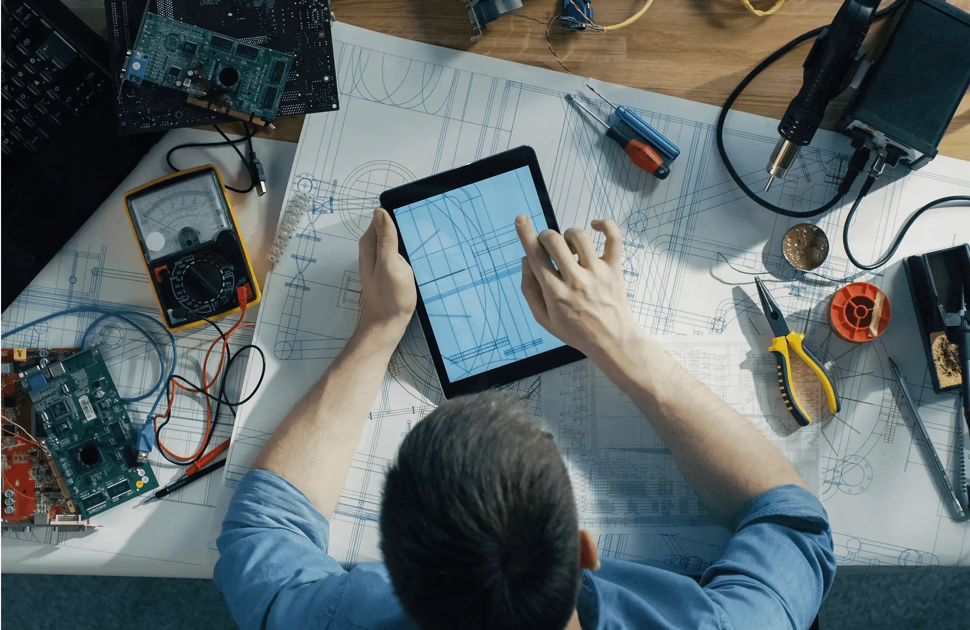 Engineer working with tablet and electronic tools.
